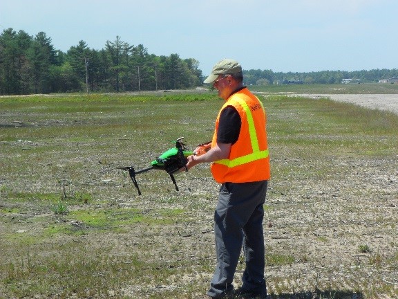 Man holding drone in a field